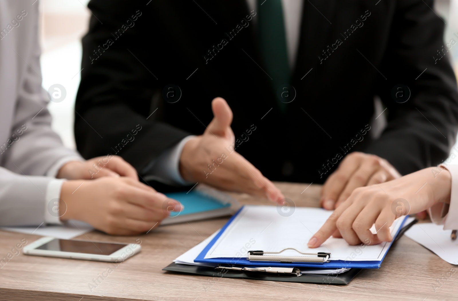 Photo of Young consultant working with clients in office