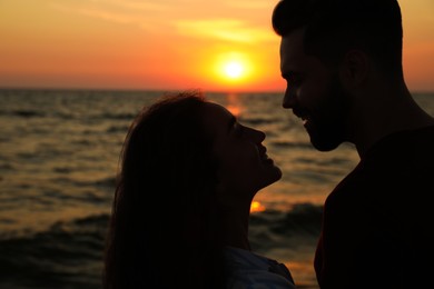 Photo of Couple spending time together on beach at sunset