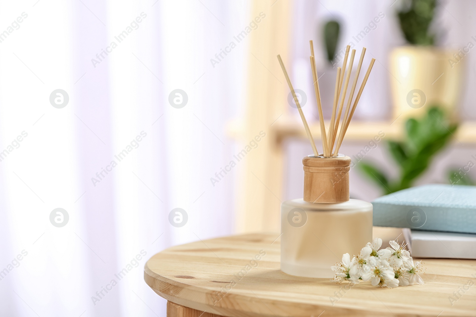 Photo of Aromatic reed freshener on table in room