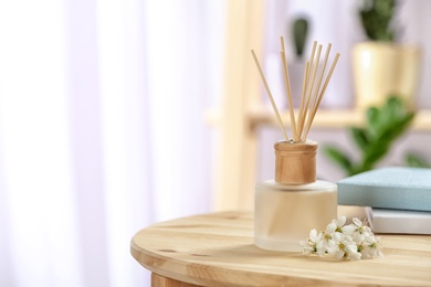 Photo of Aromatic reed freshener on table in room