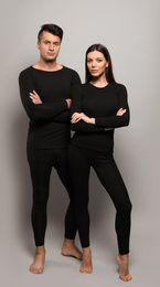 Couple wearing thermal underwear on grey background