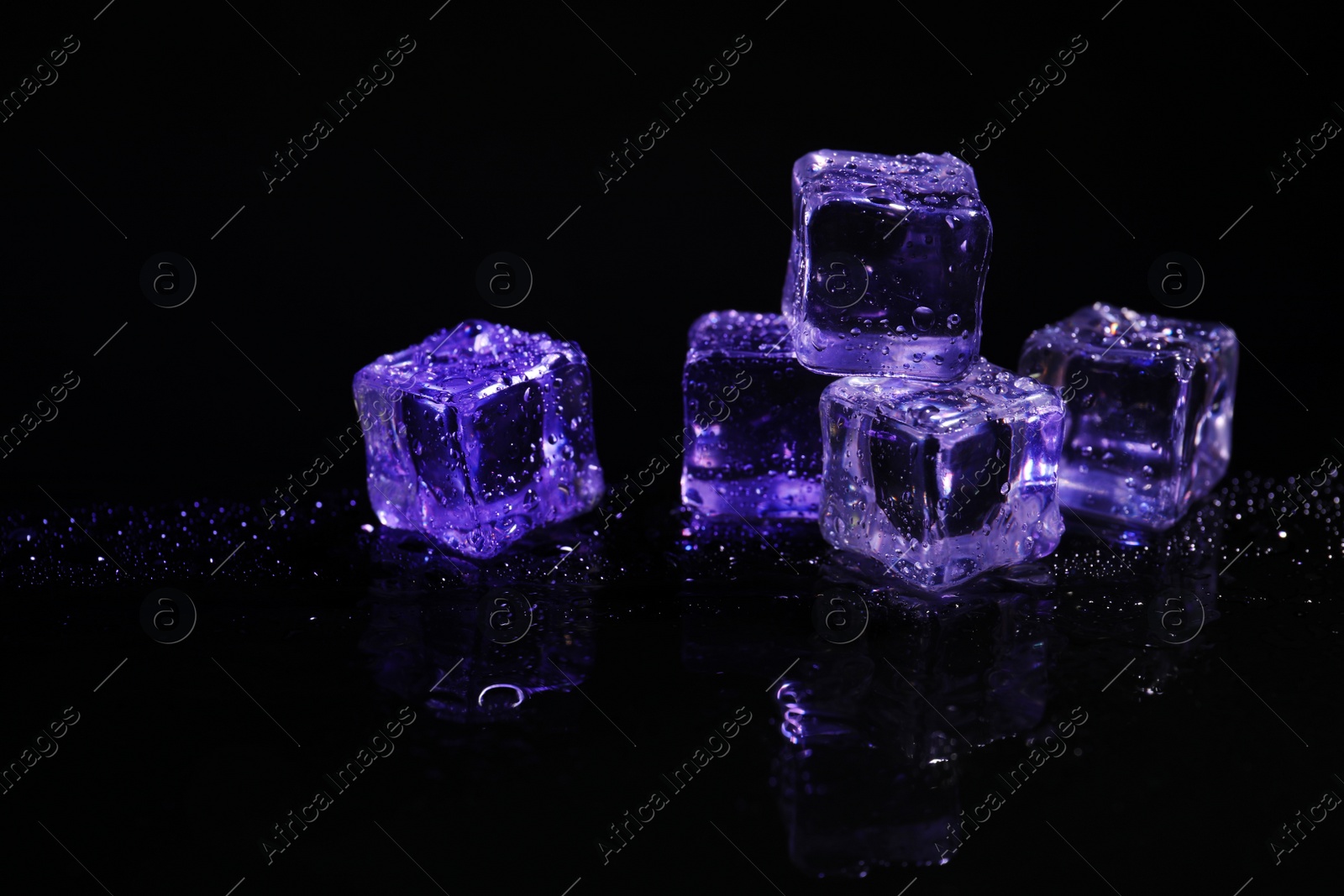 Photo of Pile of crystal clear ice cubes on black background