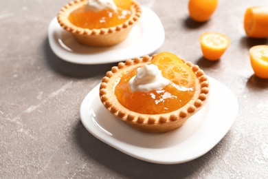 Photo of Tasty tartlets with jam on grey background