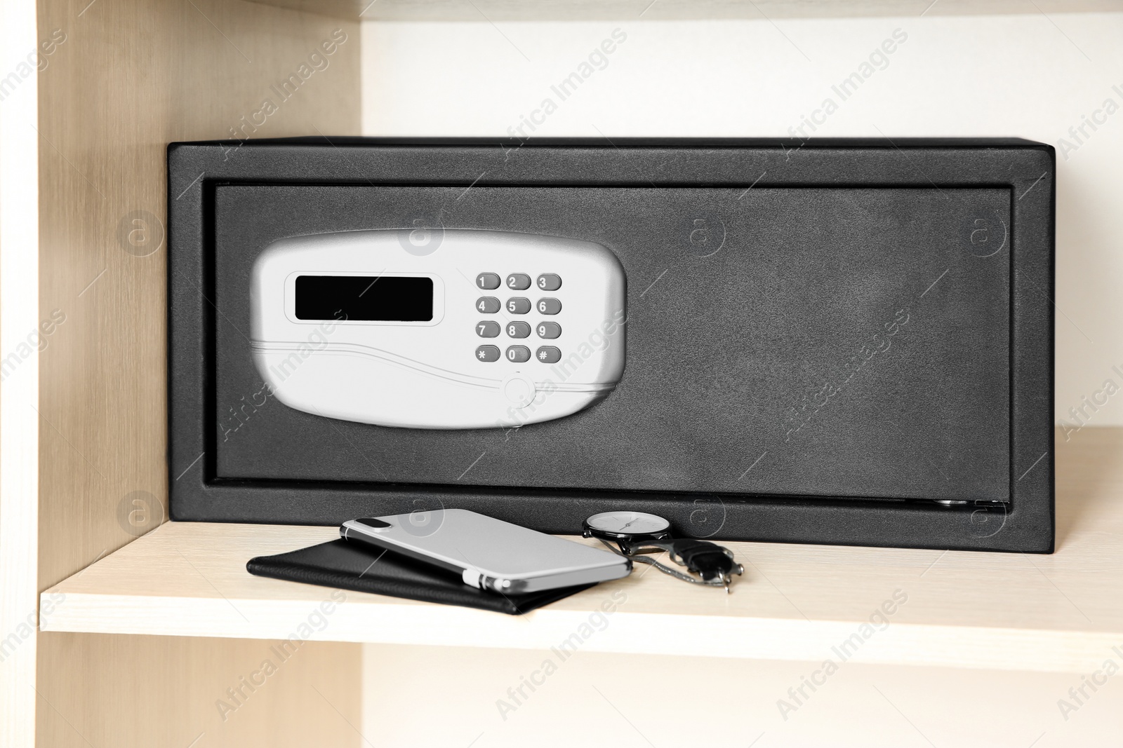 Photo of Black steel safe with electronic lock in wooden closet