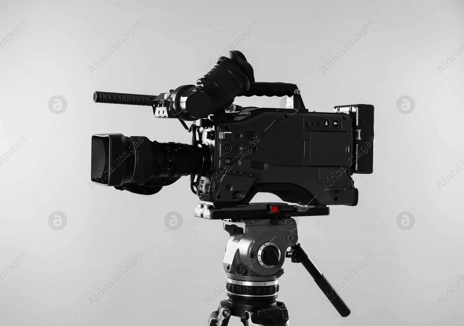 Photo of Modern professional video camera on light background