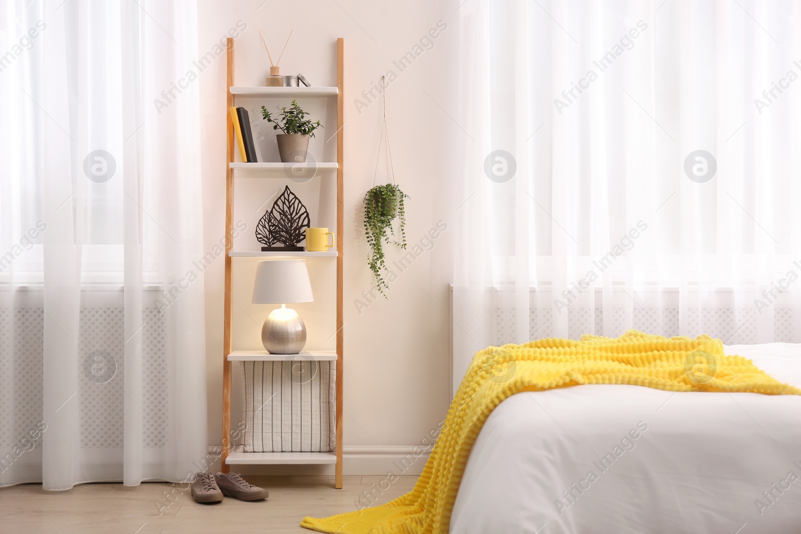 Photo of Stylish room interior with wooden ladder near white wall