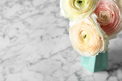 Vase with beautiful ranunculus flowers on table. Space for text