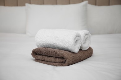 Soft clean terry towels on white bed