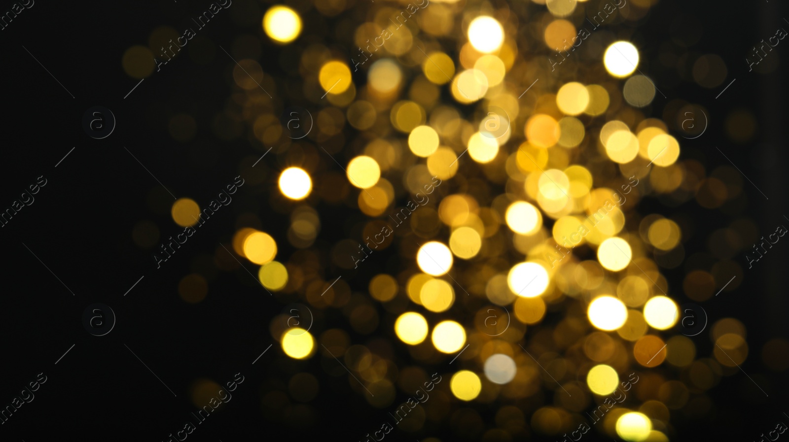 Photo of Blurred view of golden lights on black background. Bokeh effect
