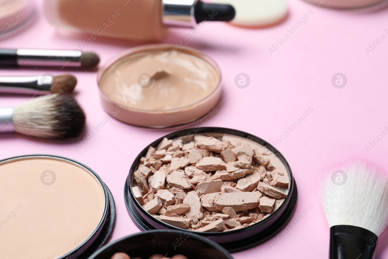 Photo of Composition with powder, skin foundation and beauty accessories on color background