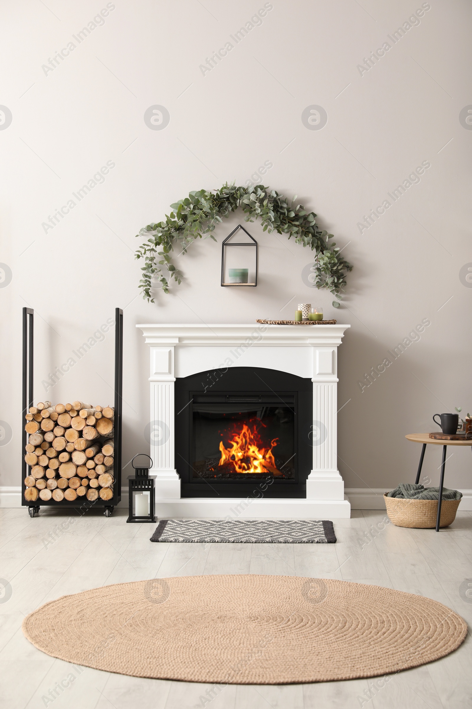 Photo of Stylish room decorated with beautiful eucalyptus garland above fireplace