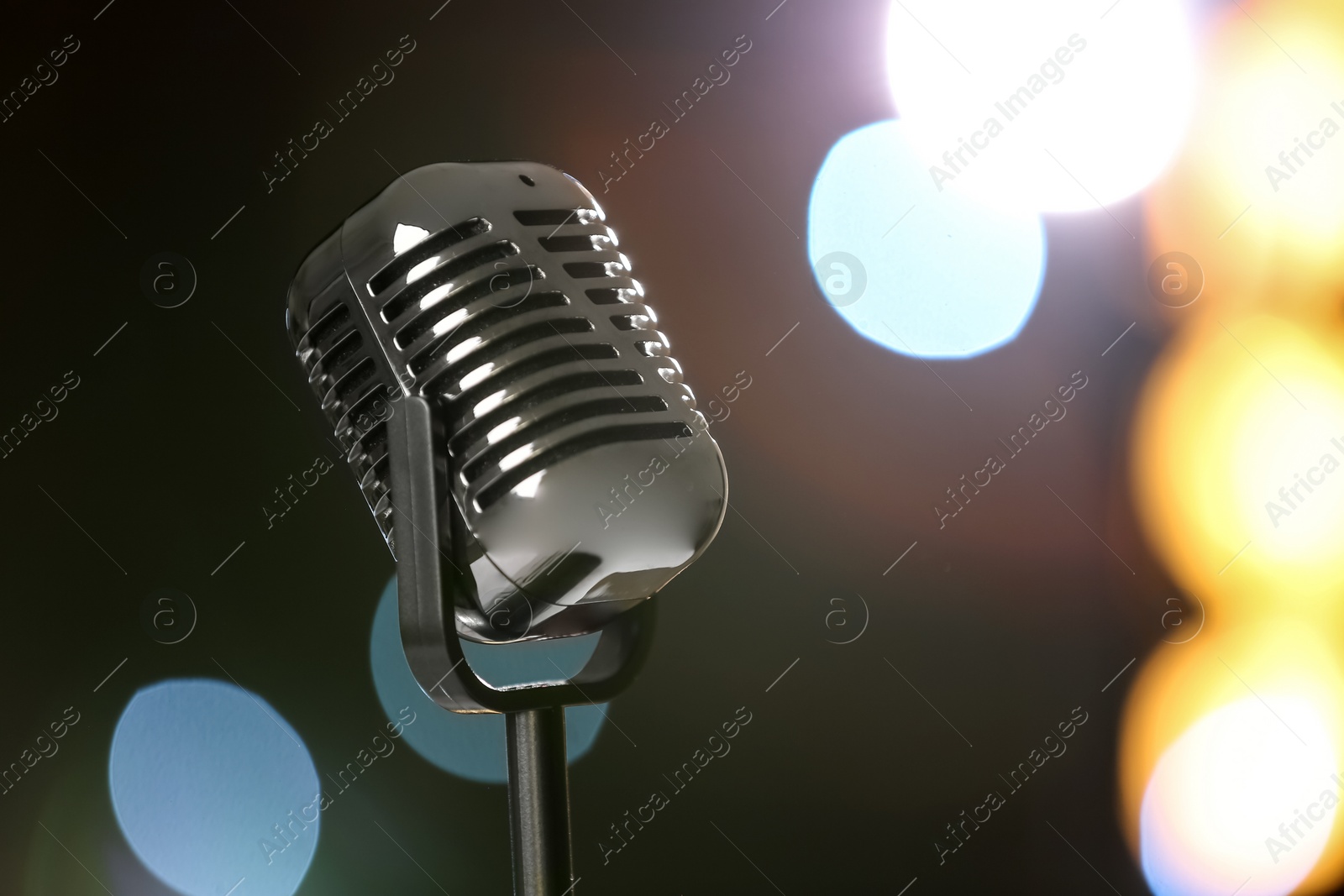 Photo of Retro microphone against festive lights, space for text. Musical equipment