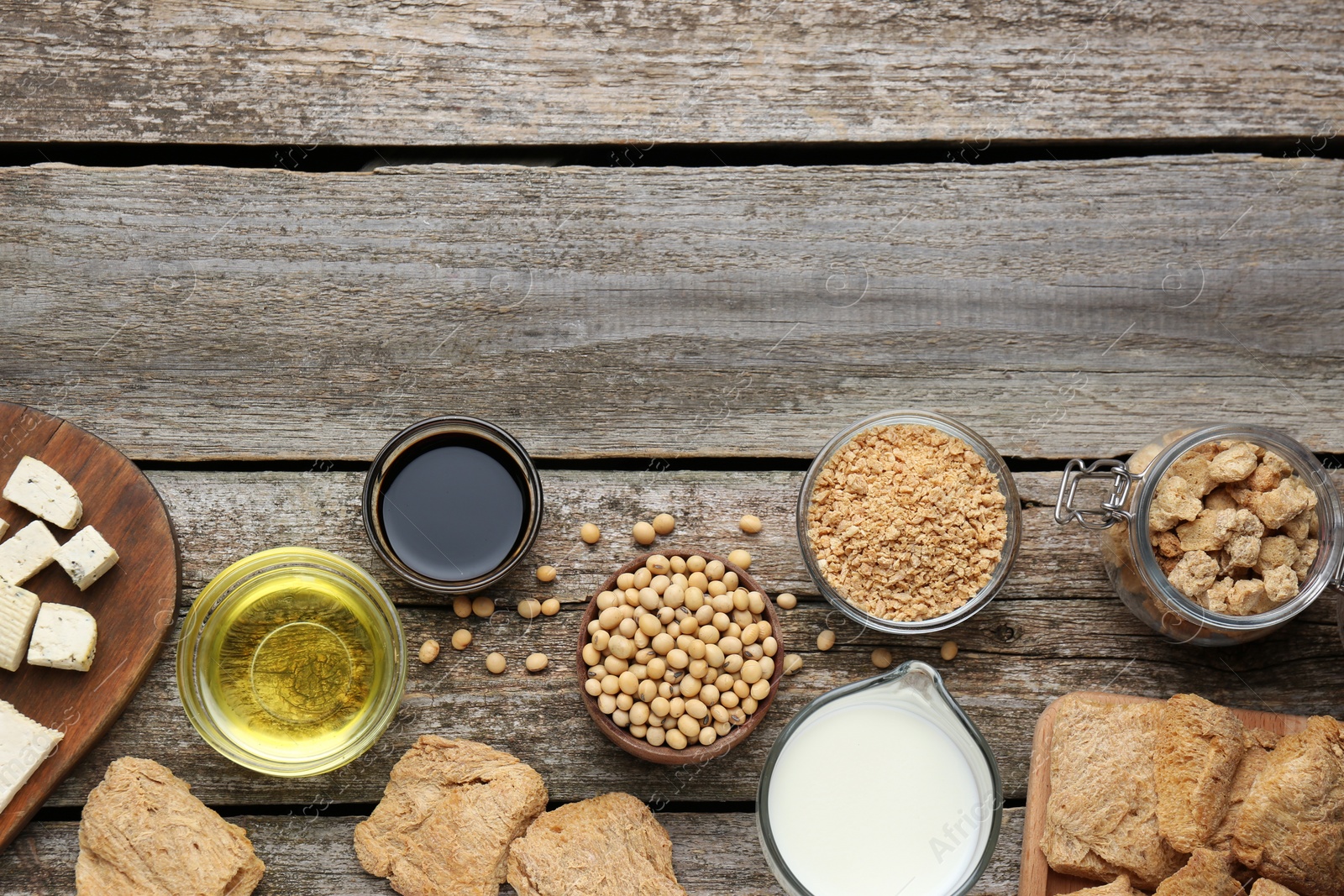 Photo of Different natural soy products on wooden table, flat lay. Space for text