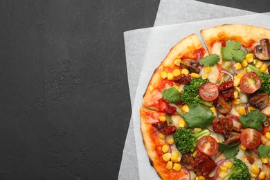 Photo of Delicious vegetarian pizza with mushrooms, vegetables and parsley on black table, top view. Space for text