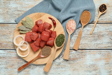Raw beef meat and different ingredients for cooking delicious goulash on wooden table, flat lay