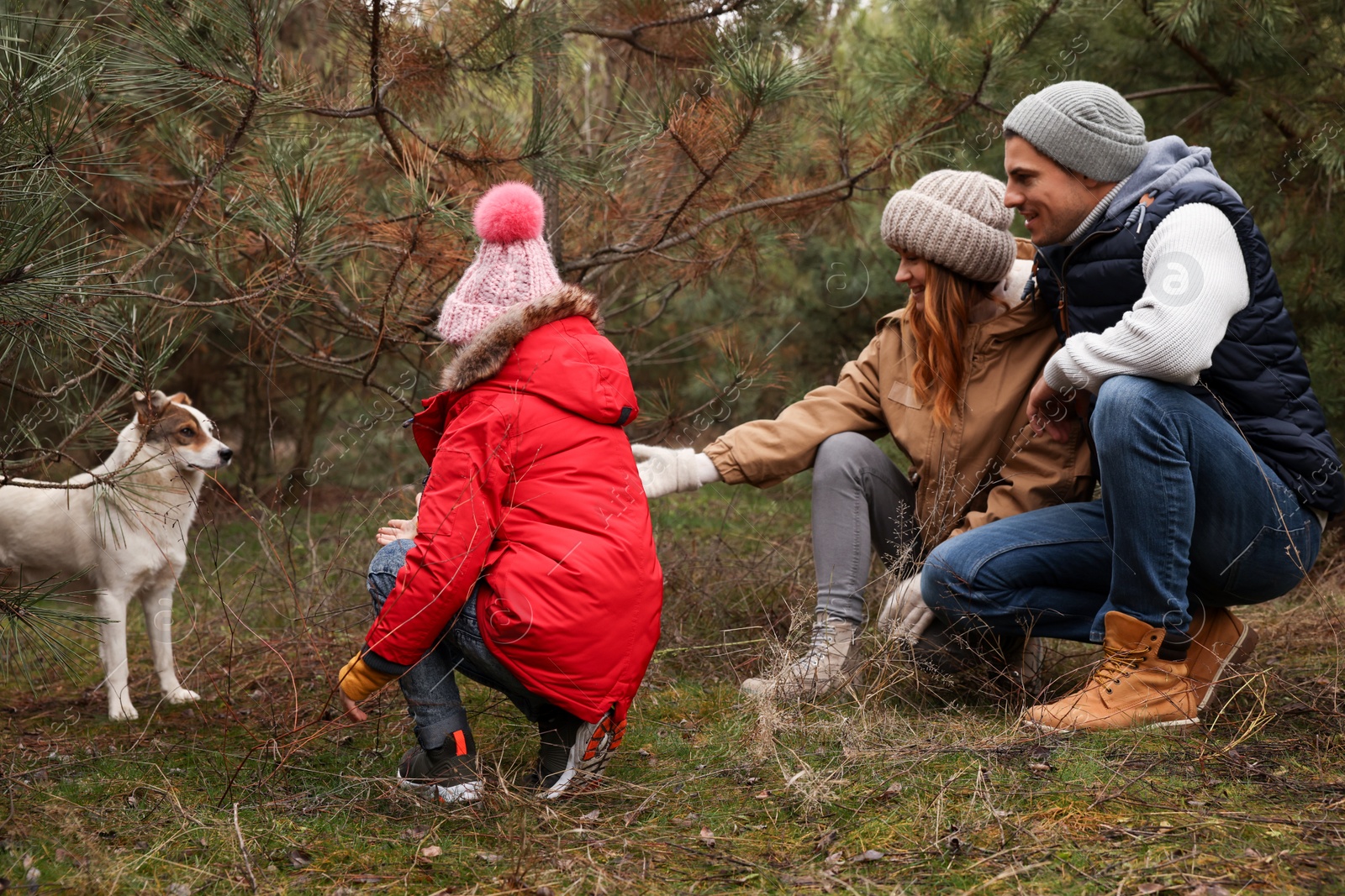 Photo of Happy family with dog spending time together in forest