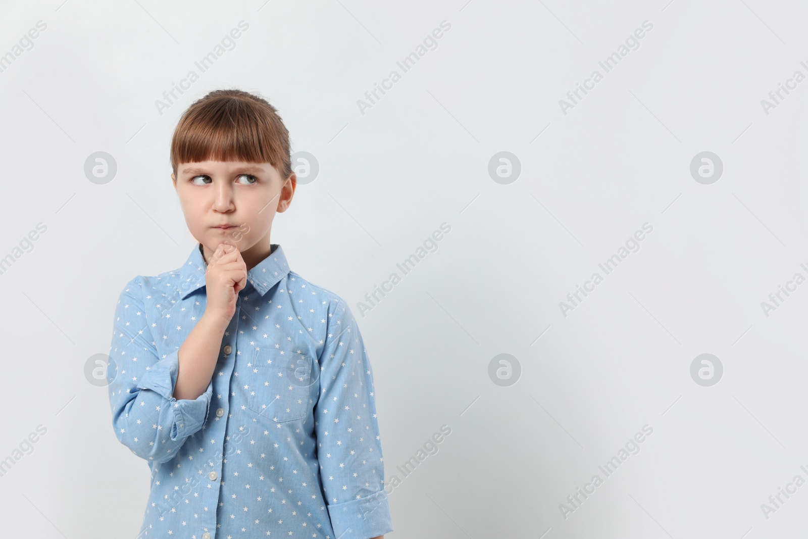 Photo of Pensive little girl on white background, space for text. Thinking about answer to question