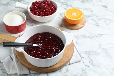 Photo of Fresh cranberry sauce in bowl served on white marble table, space for text