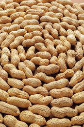 Many fresh unpeeled peanuts as background, closeup