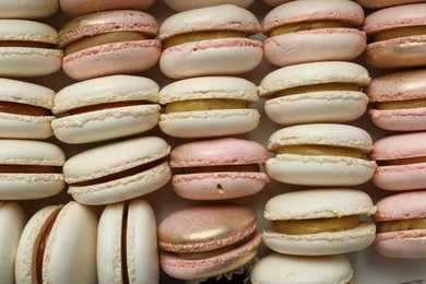 Photo of Different delicious macarons as background, top view