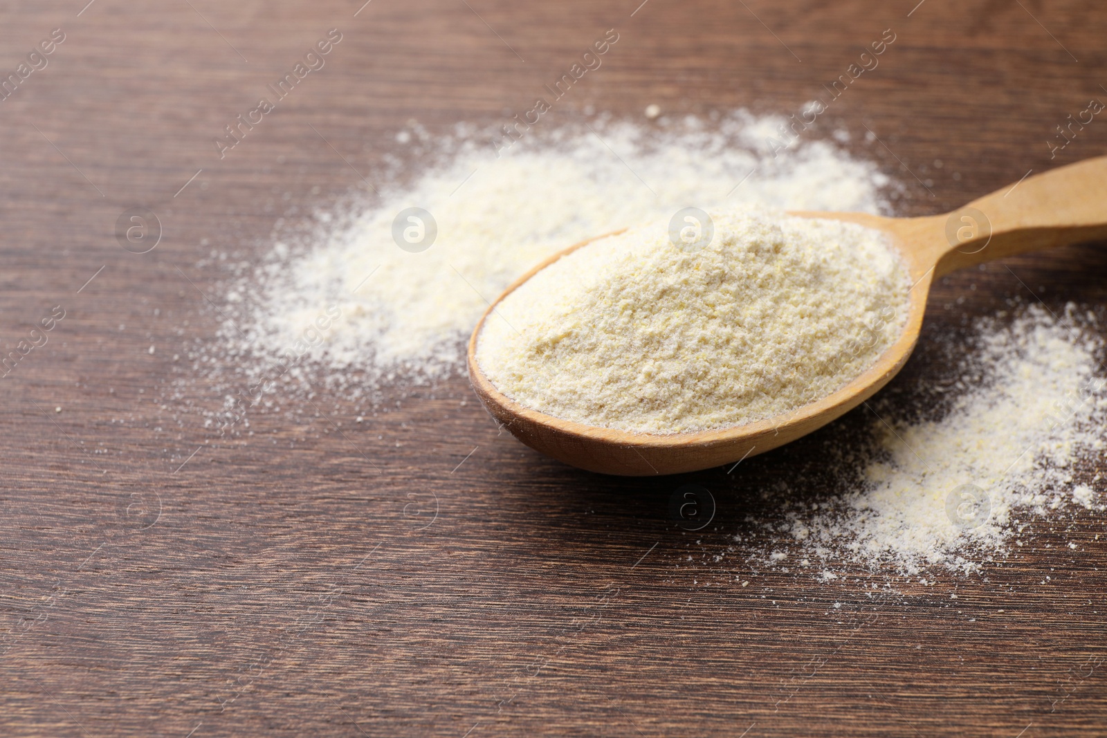 Photo of Spoon with quinoa flour on wooden table. Space for text