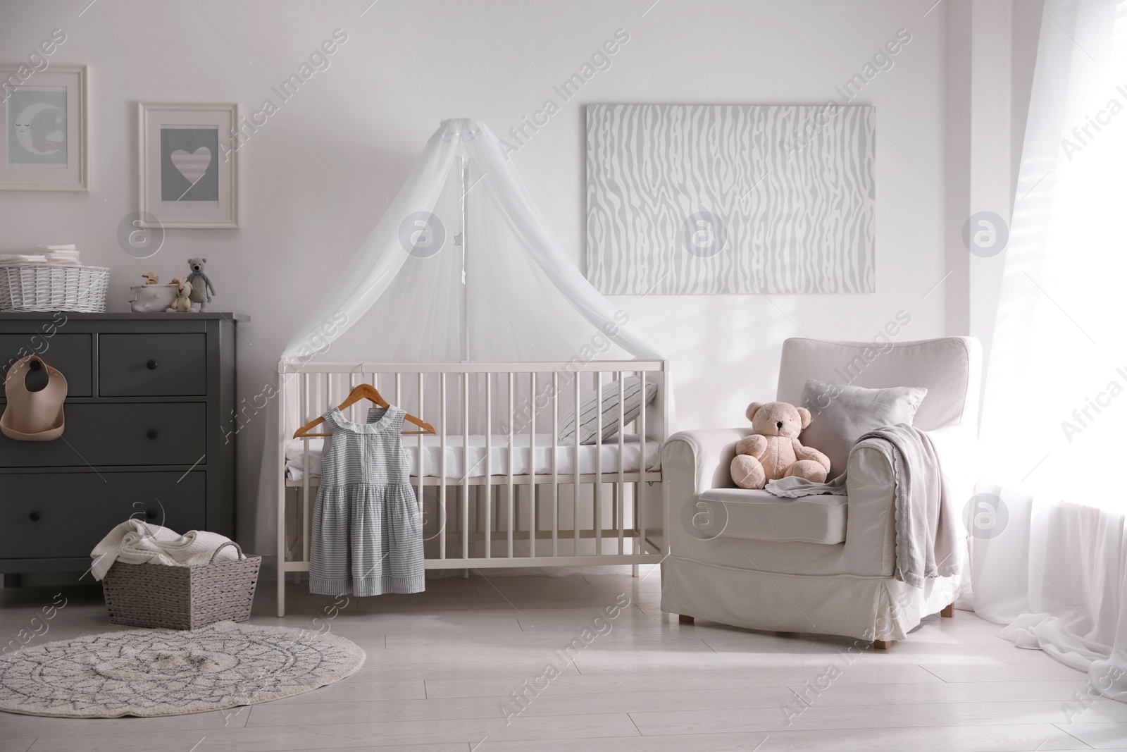 Photo of Baby room interior with comfortable crib and armchair