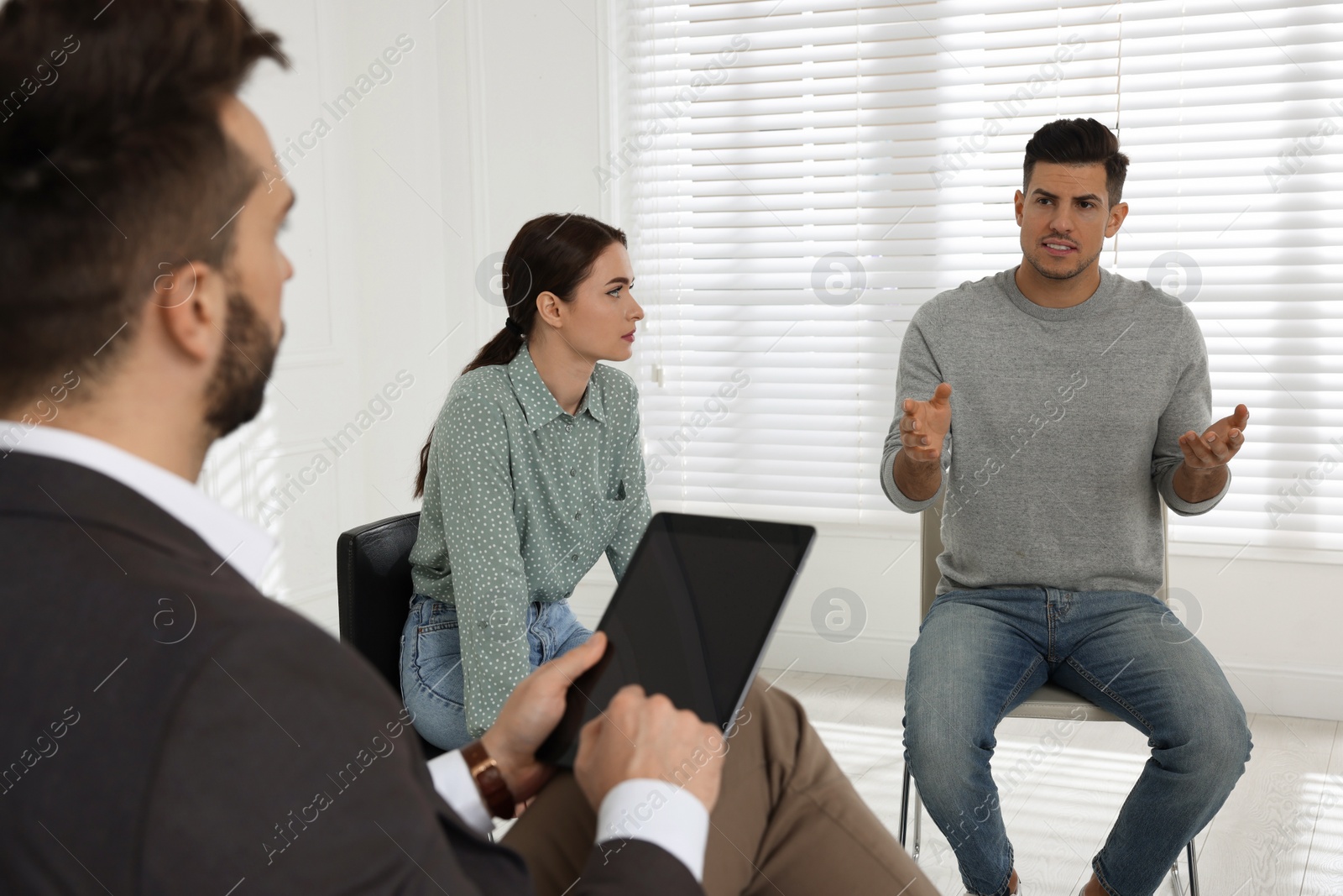 Photo of Psychotherapist working with patients at group session indoors