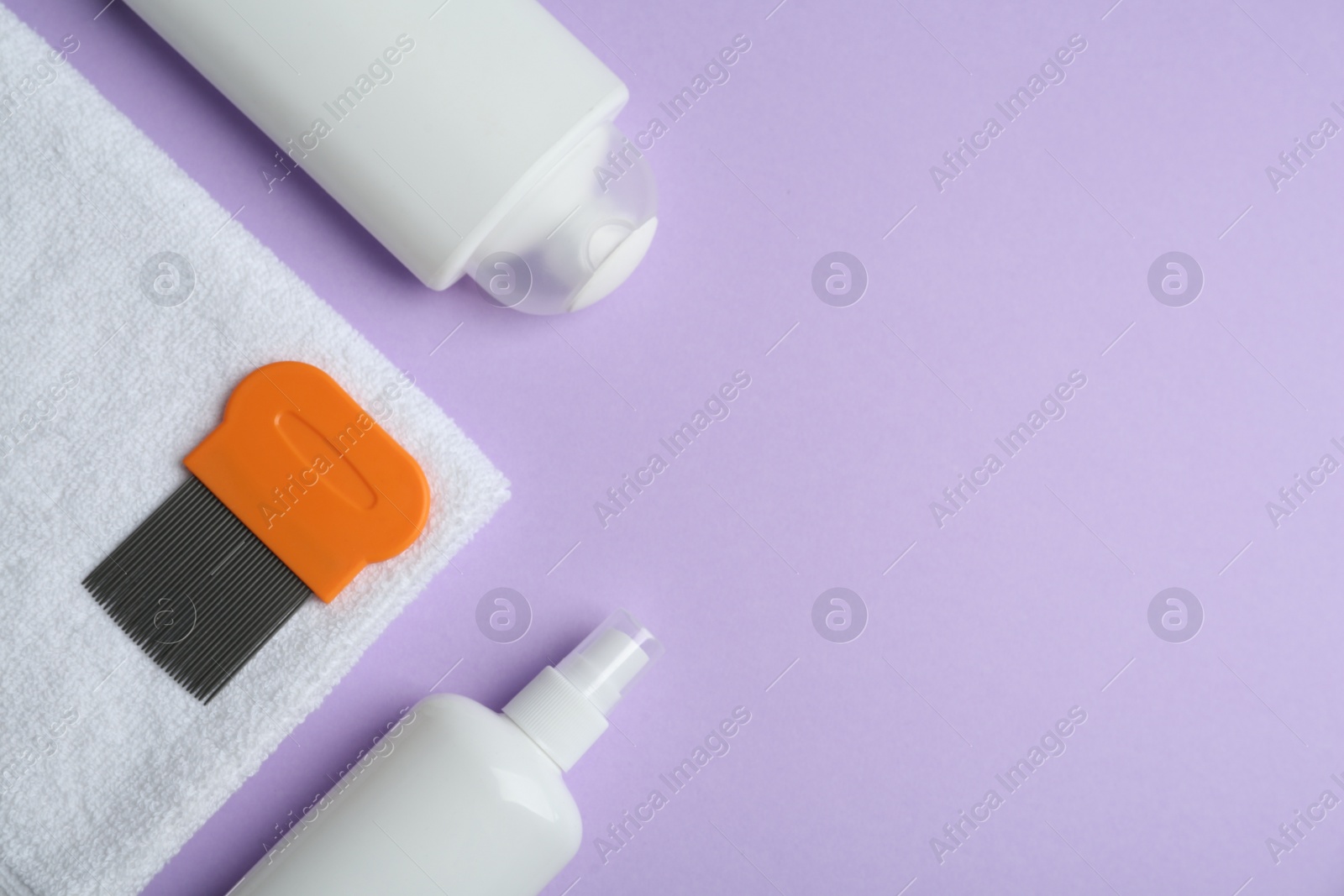 Photo of Anti lice products in bottles, comb and towel on violet background, flat lay. Space for text
