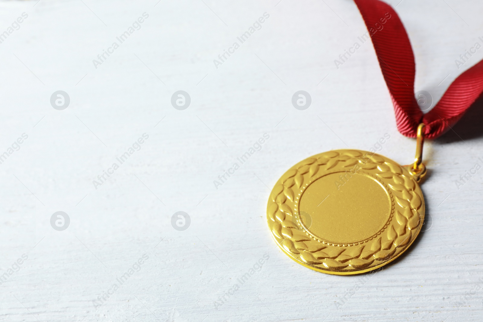 Photo of Gold medal with space for design on white wooden background. Victory concept