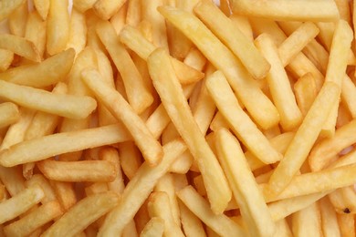 Photo of Many delicious French fry pieces as background