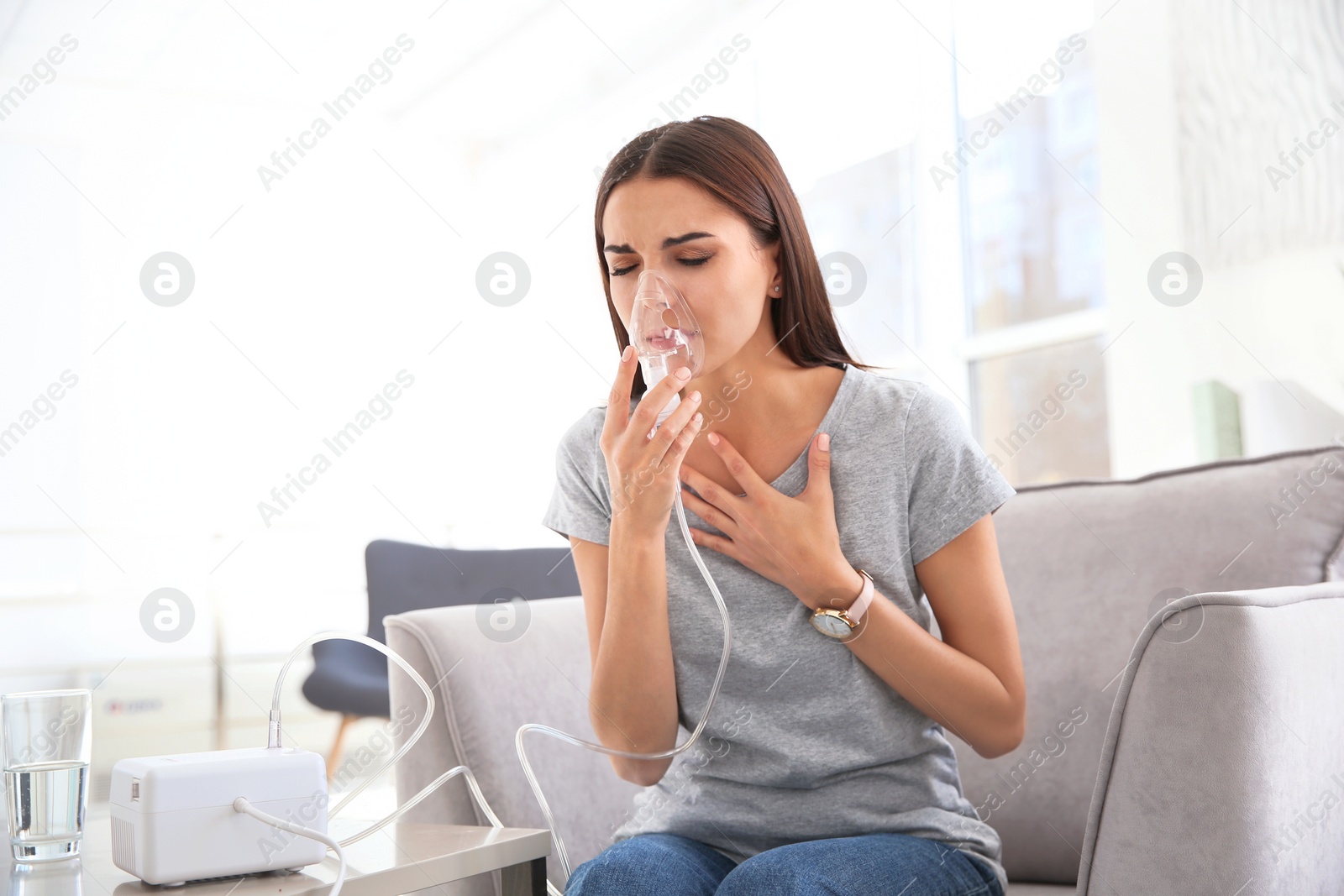 Photo of Young woman with asthma machine in light room