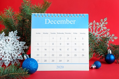 Photo of Flip calendar and Christmas decor on red background. Holiday countdown