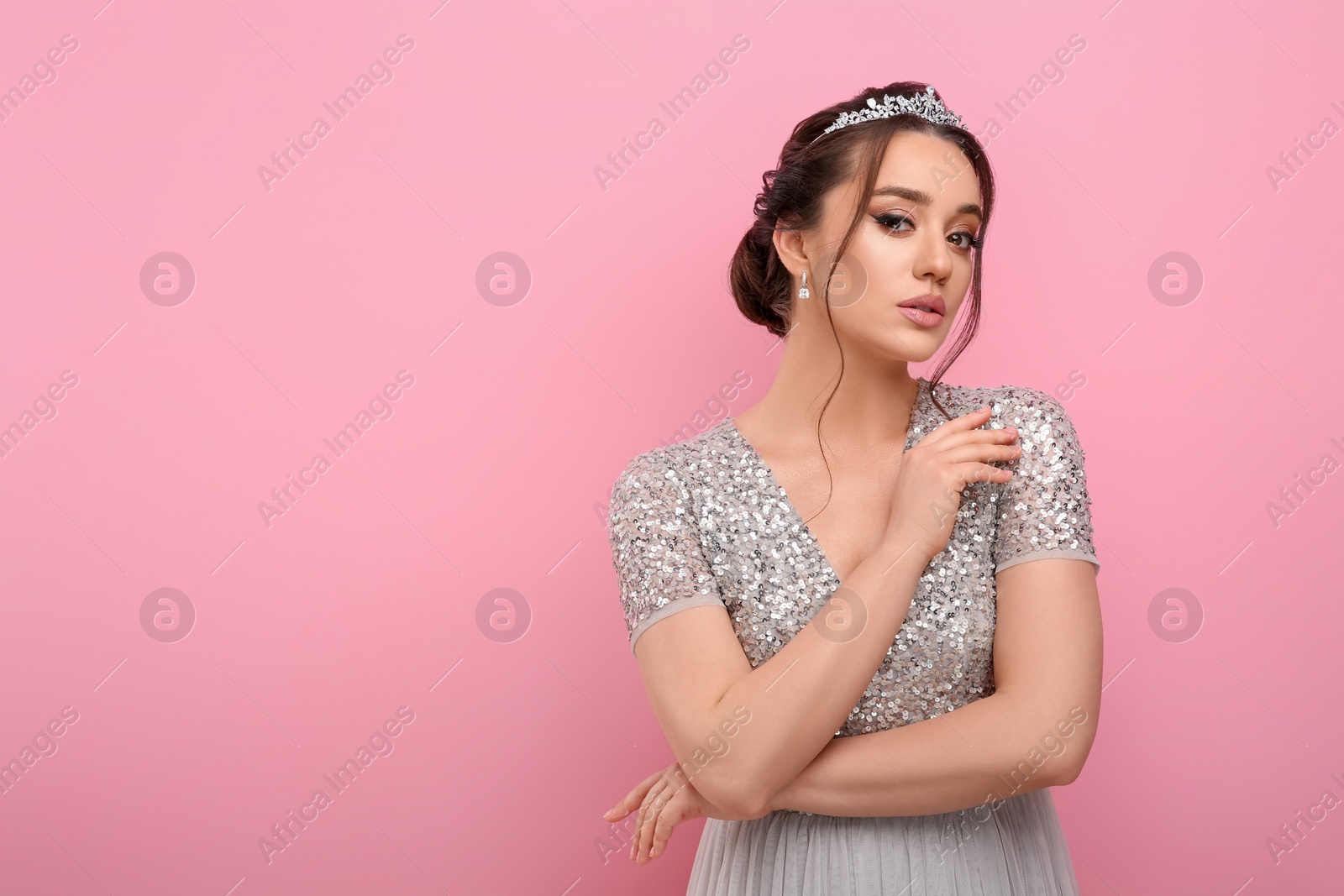 Photo of Beautiful young woman wearing luxurious tiara on pink background, space for text