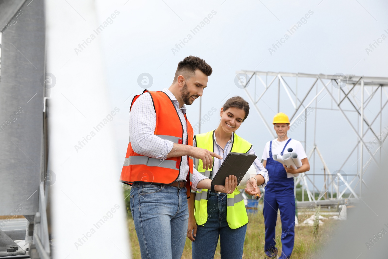 Photo of Professional engineers working on installation of electrical substation outdoors