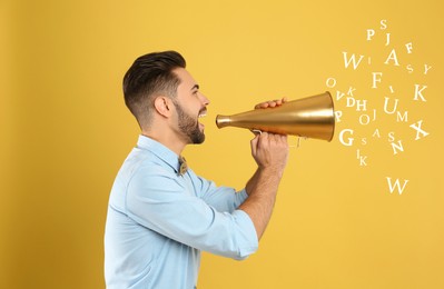 Man using megaphone on yellow background. Letters flying out of device