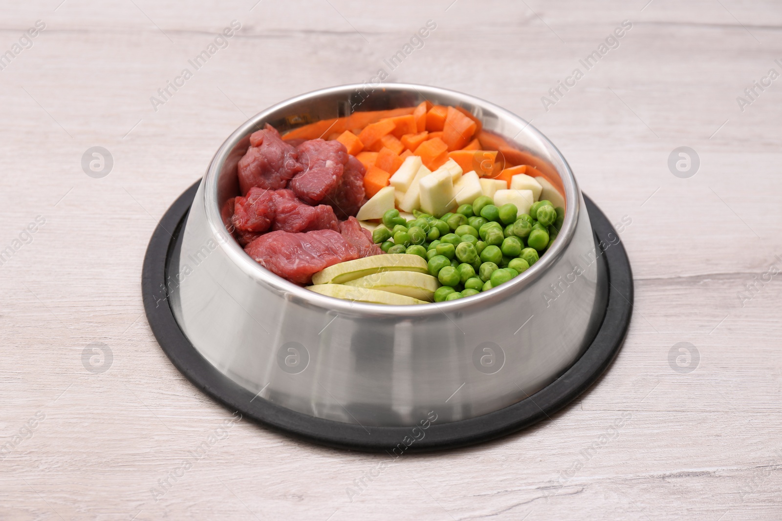 Photo of Bowl with organic dog food on light background