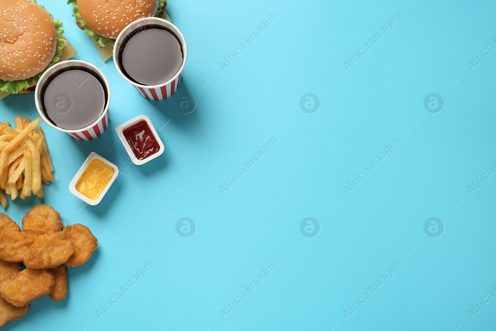 Photo of Flat lay composition with delicious fast food menu on light blue background. Space for text