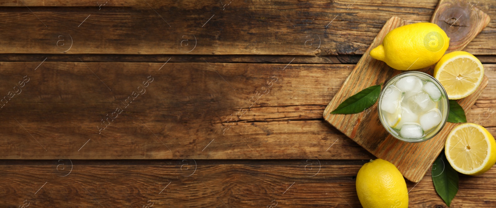 Image of Cool freshly made lemonade and fruits on wooden table, flat lay with space for text. Banner design