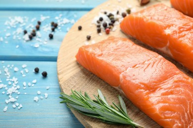 Photo of Fresh raw salmon and ingredients for marinade on light blue wooden table, closeup. Space for text