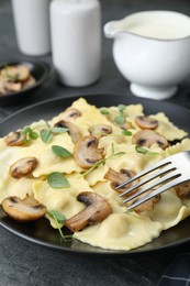 Photo of Delicious ravioli with mushrooms served on grey table, closeup
