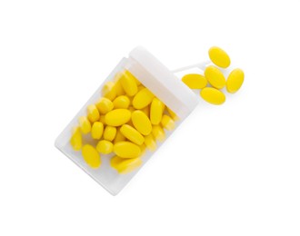 Photo of Tasty yellow dragee candies in box on white background, top view