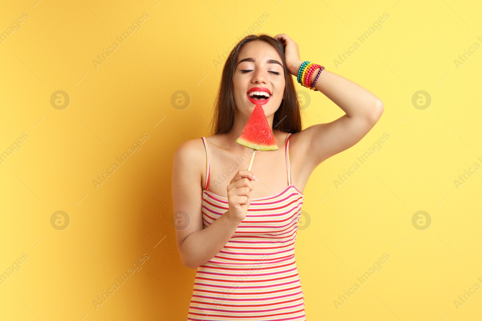 Photo of Beautiful young woman posing with watermelon on color background