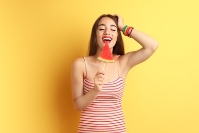 Beautiful young woman posing with watermelon on color background