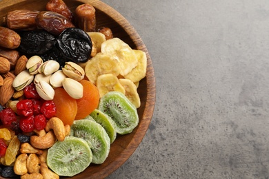 Photo of Plate with different dried fruits and nuts on table, closeup. Space for text