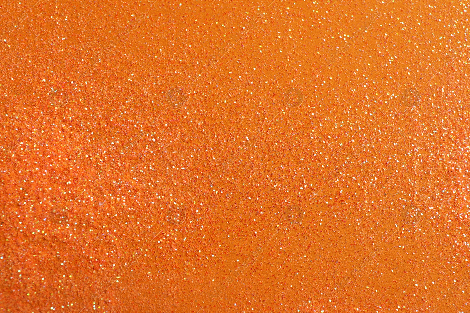 Photo of Shiny bright glitter on orange background, flat lay