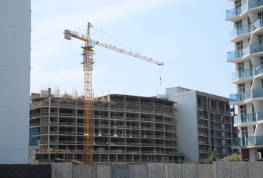 Construction site with tower crane near unfinished buildings