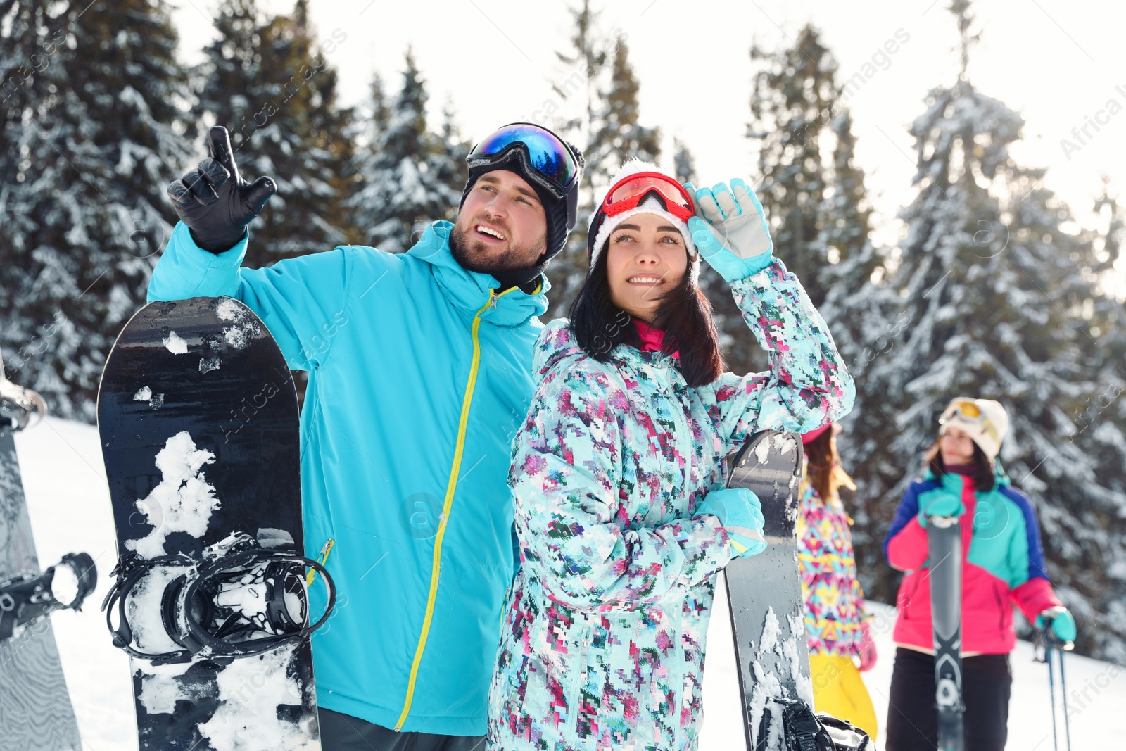 Photo of Happy couple with friends on snowy slope. Winter vacation