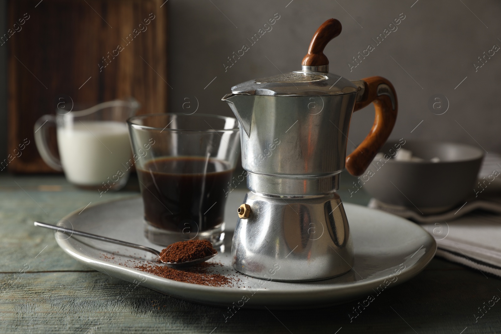 Photo of Brewed coffee in glass and moka pot on rustic wooden table