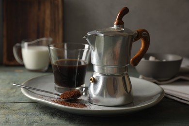 Brewed coffee in glass and moka pot on rustic wooden table