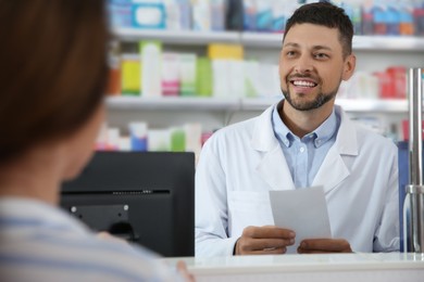Photo of Professional pharmacist working with customer in drugstore